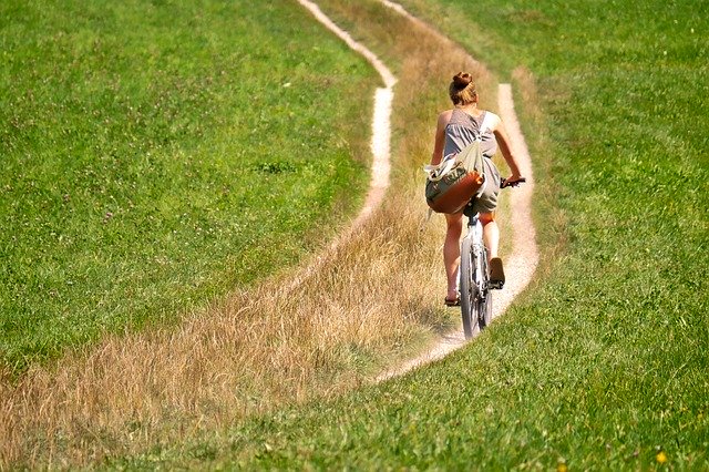 žena jedoucí na kole v přírodě